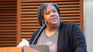 Gina Green-Harris gives a presentation at a podium for ADRD Research Day 2025