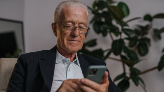Person using a smartphone, illustrating at-home digital memory testing for Alzheimer’s disease research.