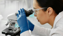 Photo of woman looking through microscope
