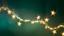 Star shaped holiday lights lit up in front of a green background